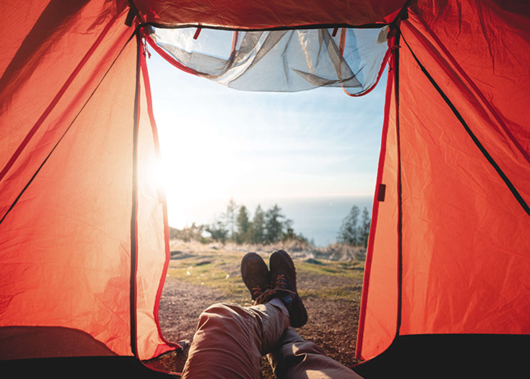 Pitching a tent and relaxing on a hillside while camping on federal and state land.